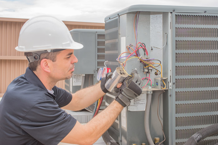 man servicing HVAC unit